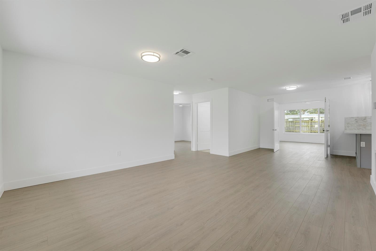 An open-concept living area features white walls, light wood-look flooring, and recessed lighting — 4142 Kirkland Lane, Lake Worth FL 33461, LAKE WORTH, FL