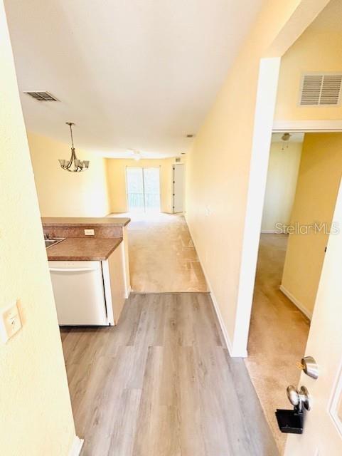 A view from a doorway looking into a kitchen with light wood-look flooring and carpet — 14201 INDIAN CREEK DRIVE UNIT 14201, KISSIMMEE, FL