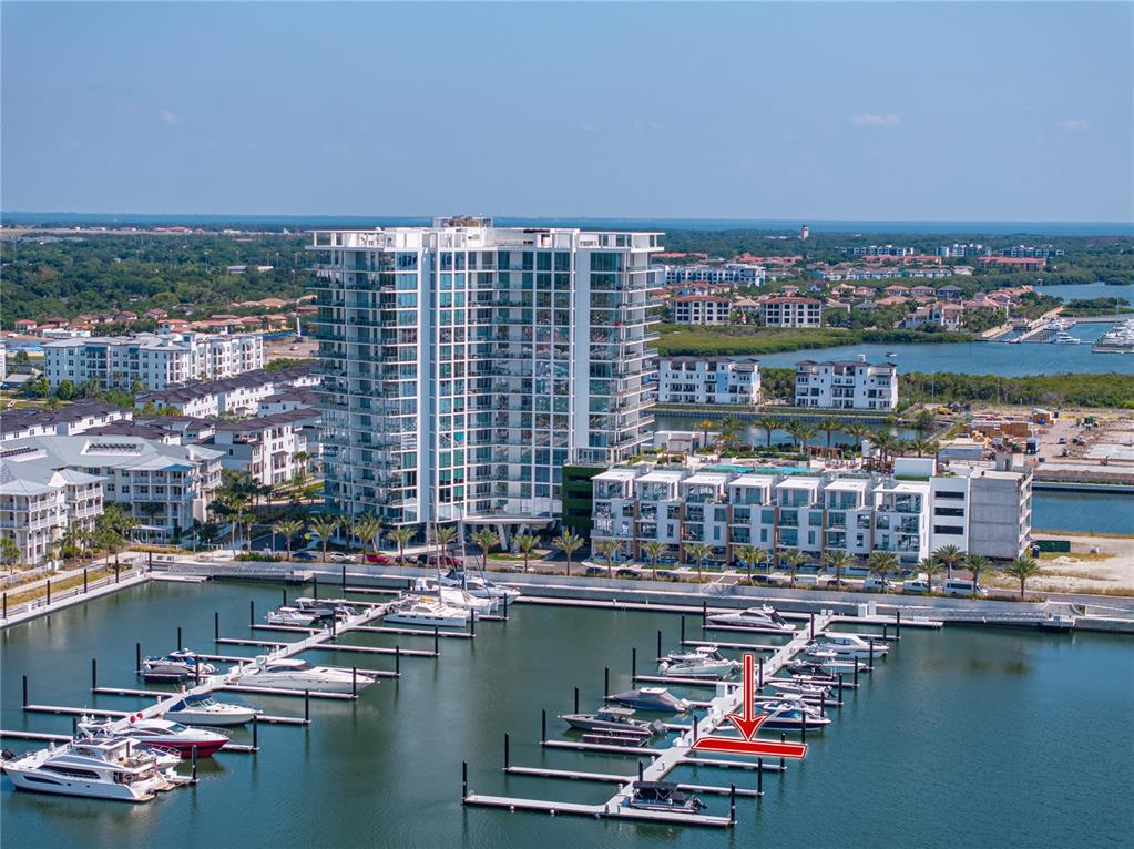 An aerial view shows a high-rise apartment building overlooking a marina with docked boats — 5120 MARINA WAY UNIT D-W-15, TAMPA, FL
