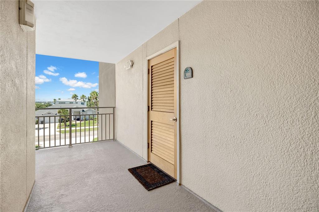 A living room features a brown sectional, two blue armchairs, and a balcony with ocean views — 4505 S ATLANTIC AVENUE UNIT 305, PONCE INLET, FL