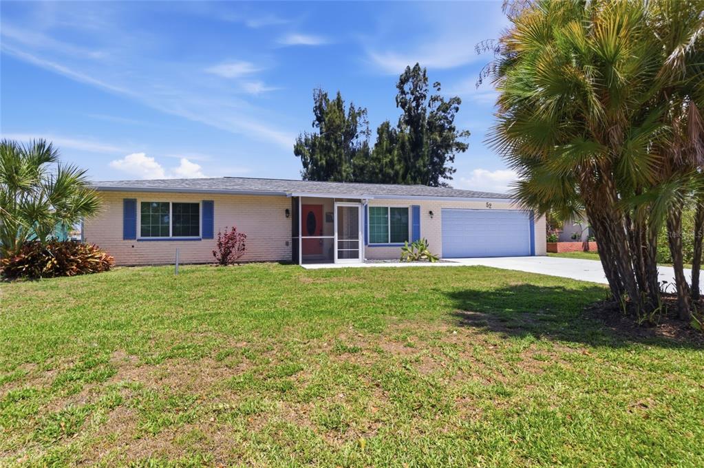 A single-story brick house with a blue garage door and blue window shutters — 52 ANNAPOLIS LANE, ROTONDA WEST, FL