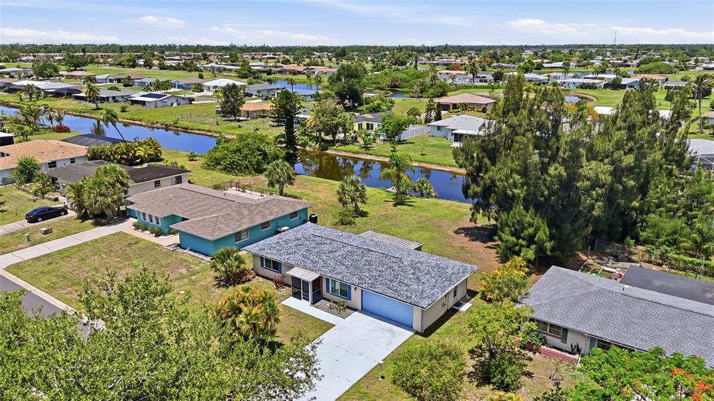 An aerial view shows a residential neighborhood with single-story houses, lawns, and a canal — 52 ANNAPOLIS LANE, ROTONDA WEST, FL