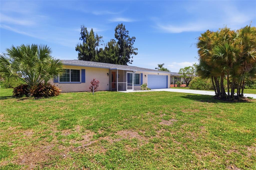 A single-story house with a brick exterior, blue shutters, and a two-car garage — 52 ANNAPOLIS LANE, ROTONDA WEST, FL