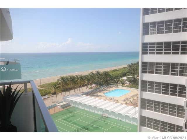 A high-angle view from a balcony overlooking a tennis court, swimming pool, and the ocean — 5151 COLLINS AV # 1030, Miami Beach FL 33140, MIAMI BEACH, FL