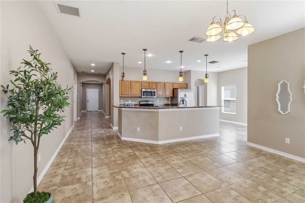 A kitchen with light wood cabinets and a breakfast bar overlooks a tiled dining area — 820 PARKER DEN DRIVE, RUSKIN, FL