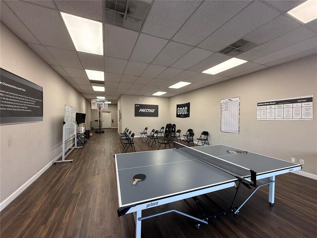 A large office break room features a ping pong table, folding chairs, and wall-mounted signage — 3917 SE LAKE WEIR AVENUE, OCALA, FL