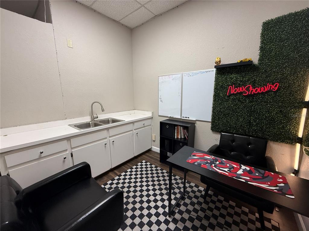 An office space features a sink, white cabinets, a desk, chairs, and a checkered floor — 3917 SE LAKE WEIR AVENUE, OCALA, FL