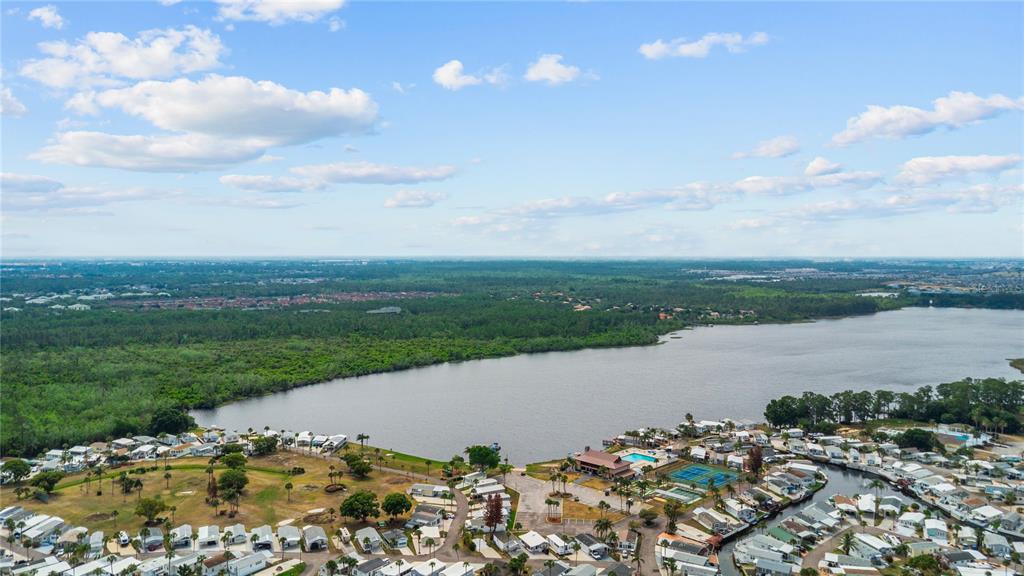 An aerial view shows a residential community with mobile homes situated along a large lake — 9000 US HIGHWAY 192 UNIT 517, CLERMONT, FL