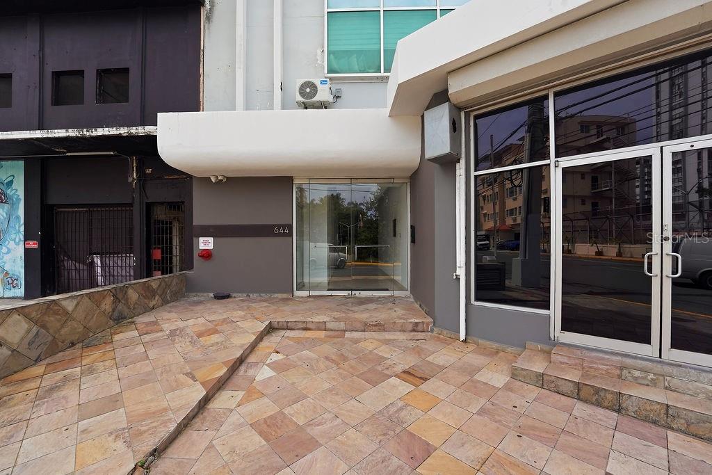 The exterior entrance of a commercial building features a tiled patio and glass doors — 644 FERNANDEZ JUNCOS UNIT 404, SAN JUAN, PR