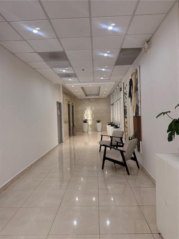 A bright hallway features light tile flooring, a drop ceiling, and two modern armchairs — 644 FERNANDEZ JUNCOS UNIT 404, SAN JUAN, PR
