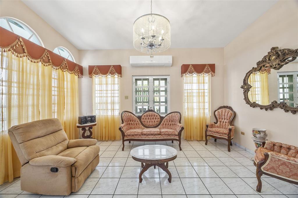 A living room features tile floors, a crystal chandelier, vintage-style furniture, and yellow window curtains — SR 301 Km. 3.2 Interior BOQUERON, CABO ROJO, PR