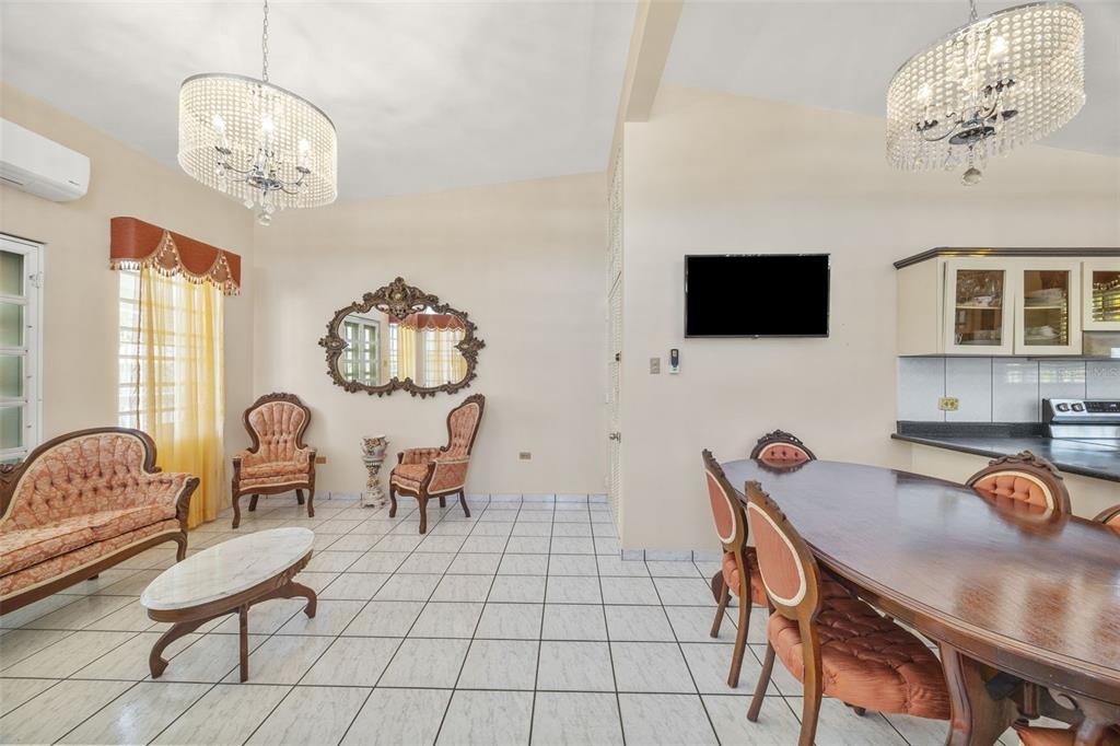 An open-concept living and dining area features tiled floors, crystal chandeliers, and traditional furniture — SR 301 Km. 3.2 Interior BOQUERON, CABO ROJO, PR