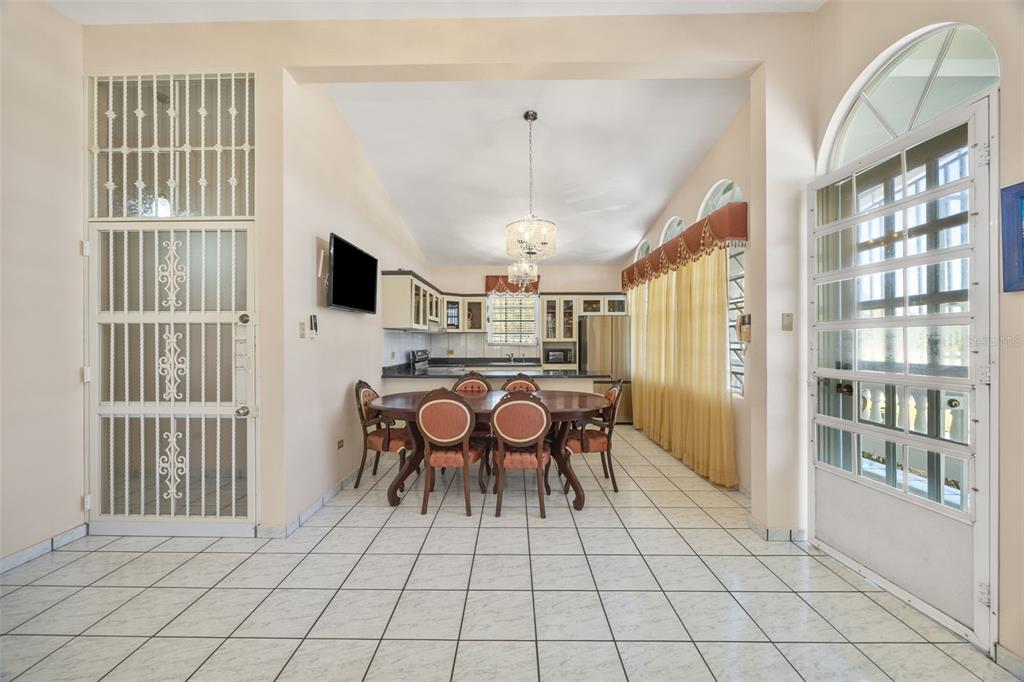 A dining area with a wooden table and chairs sits before an open-concept kitchen — SR 301 Km. 3.2 Interior BOQUERON, CABO ROJO, PR