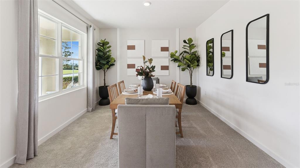 A dining room features a wooden table, upholstered chairs, potted plants, and wall mirrors — 1519 BEECHMONT DRIVE, KISSIMMEE, FL