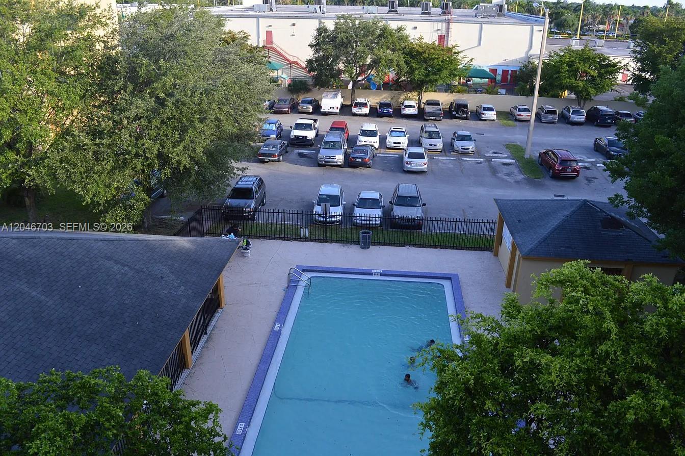An aerial view shows a swimming pool with people and a parking lot with cars — 11780 SW 18th St # 2, Miami FL 33175, MIAMI, FL