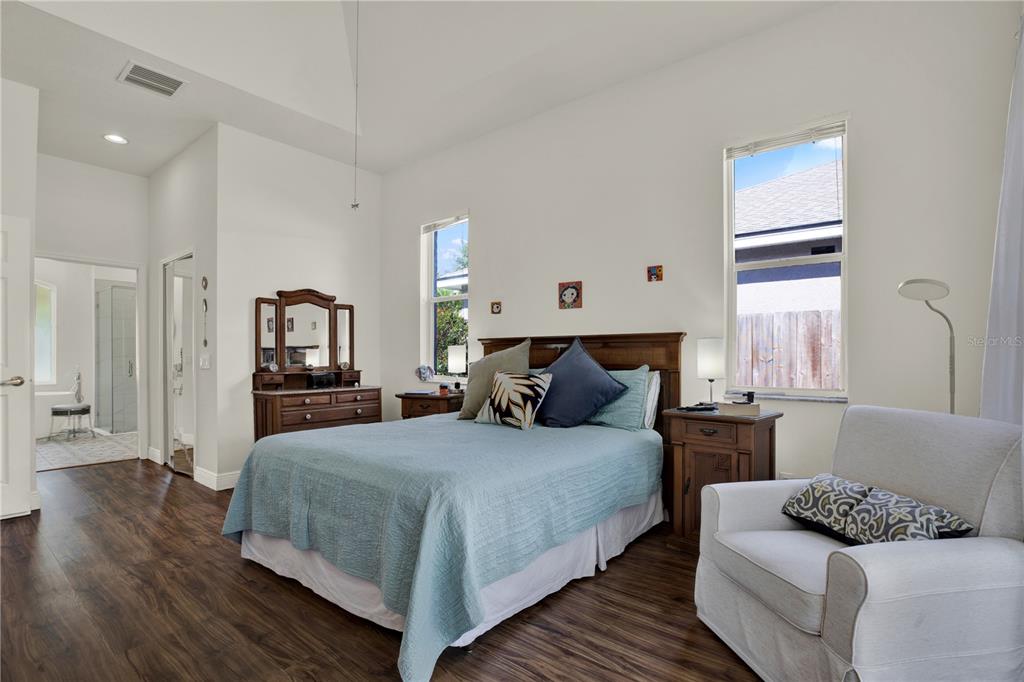 A bedroom features a queen bed, wooden furniture, white walls, and wood-look flooring — 3165 PRIDES CROSSING, TARPON SPRINGS, FL