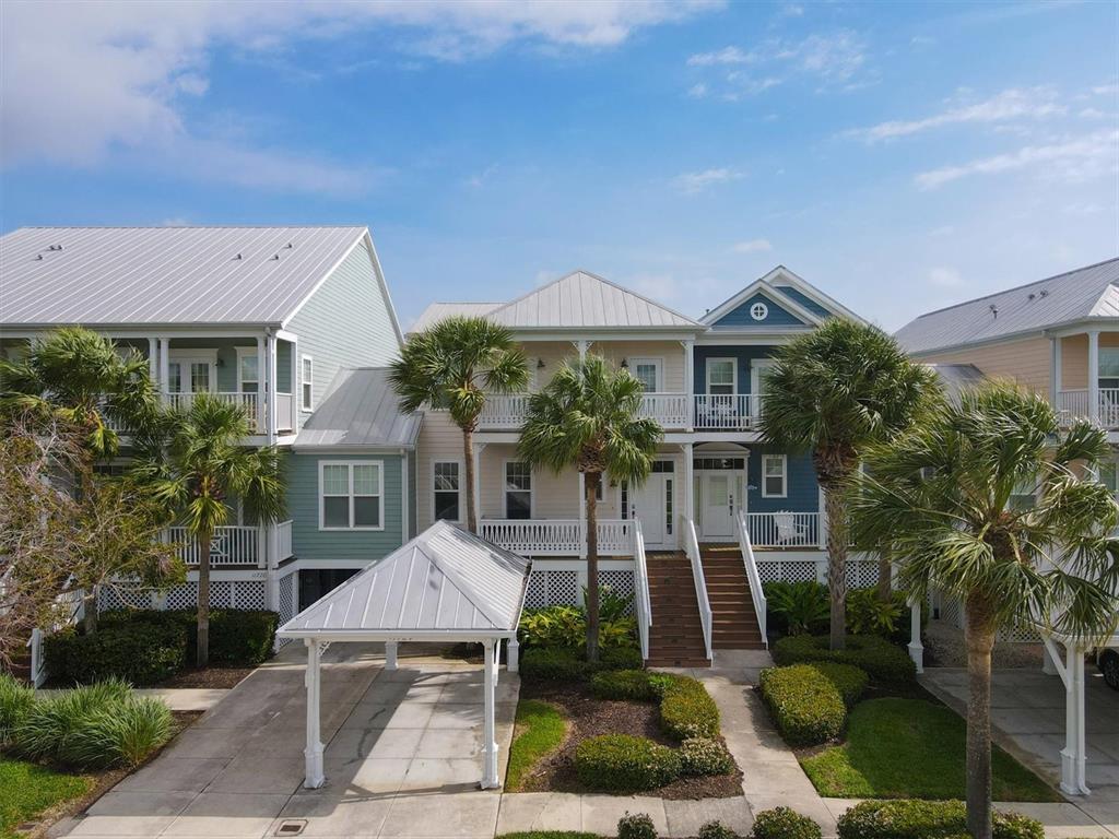 An exterior view of a multi-story coastal home with a metal roof and palm trees — 11724 ANGLERS CLUB DRIVE UNIT 121, PLACIDA, FL