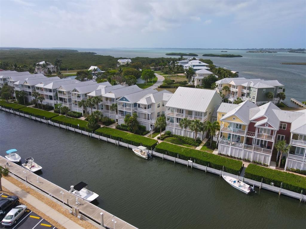 An aerial view shows a row of waterfront townhouses with private boat slips along a canal — 11724 ANGLERS CLUB DRIVE UNIT 121, PLACIDA, FL