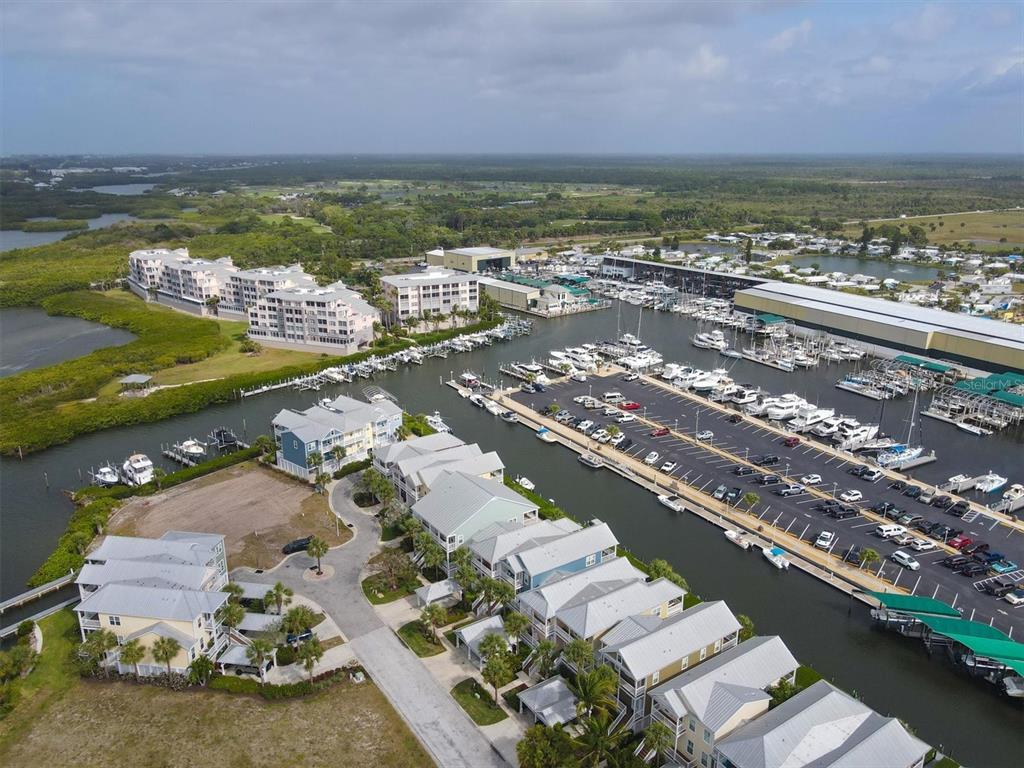 An aerial view shows a waterfront residential complex with a marina and boat storage facility — 11724 ANGLERS CLUB DRIVE UNIT 121, PLACIDA, FL