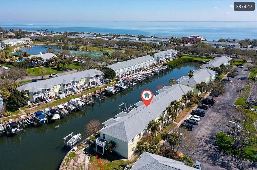 An aerial view shows a waterfront condominium complex with boat slips along a canal — 5006 STARFISH DR SE UNIT A, ST PETERSBURG, FL