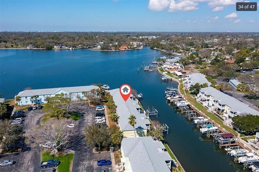 This aerial view shows a waterfront condominium complex with boat slips and a parking lot — 5006 STARFISH DR SE UNIT A, ST PETERSBURG, FL