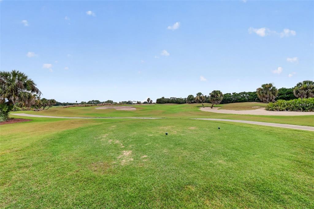 A view of a golf course fairway with sand traps and palm trees — 2773 DAY LILY RUN, THE VILLAGES, FL