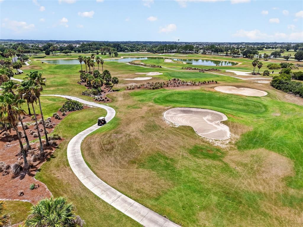 An aerial view of a golf course with a cart path and sand bunkers — 2773 DAY LILY RUN, THE VILLAGES, FL