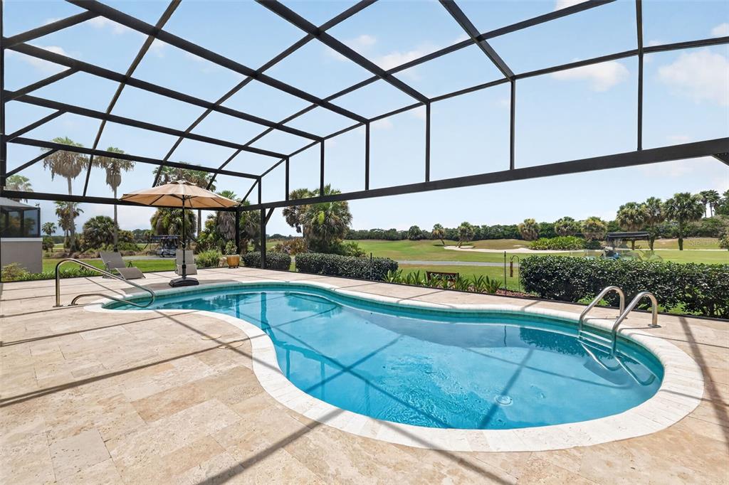 A screened-in patio features a kidney-shaped swimming pool overlooking a golf course — 2773 DAY LILY RUN, THE VILLAGES, FL