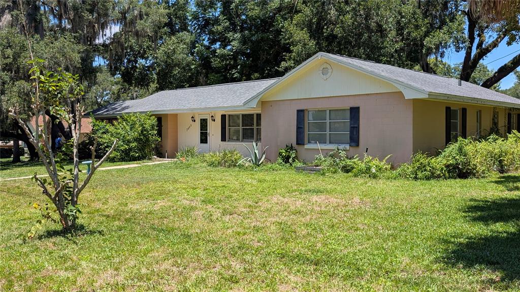 A single-story house with a light pink exterior, a gray roof, and a front lawn — 2469 BROADVUE AVENUE, EUSTIS, FL