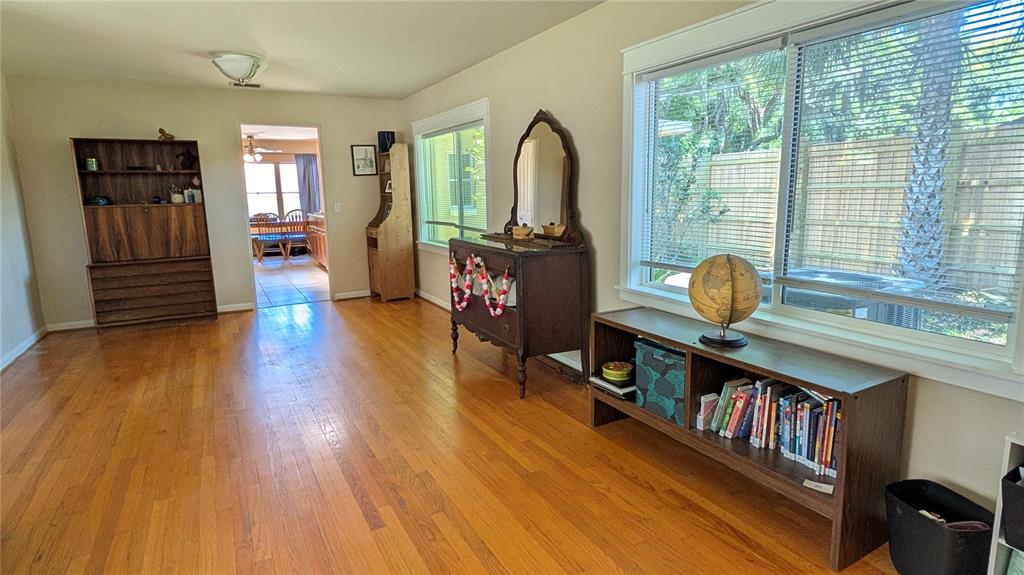 A living room features hardwood floors, a large window, and several pieces of wooden furniture — 2469 BROADVUE AVENUE, EUSTIS, FL