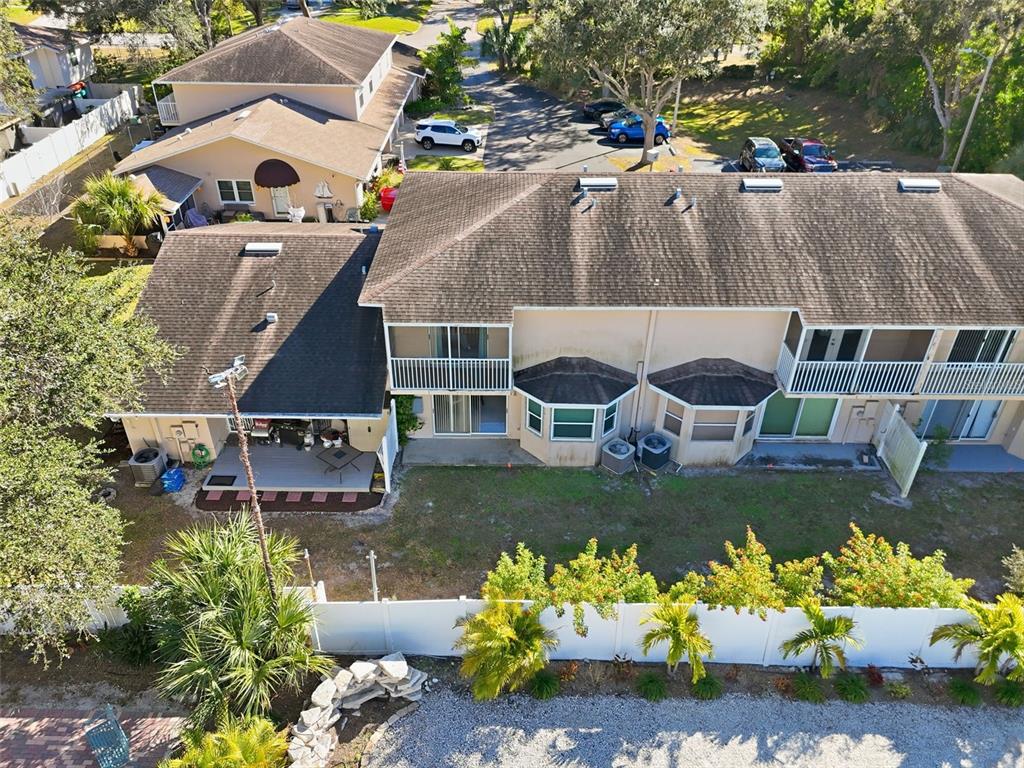 An aerial view shows the back of a multi-unit townhouse with balconies and patios — 7363 62ND AVENUE N, PINELLAS PARK, FL