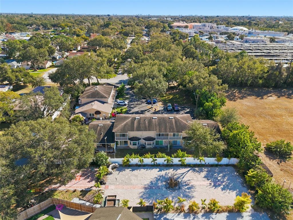 An aerial view shows a two-story apartment building with a parking lot and surrounding trees — 7363 62ND AVENUE N, PINELLAS PARK, FL