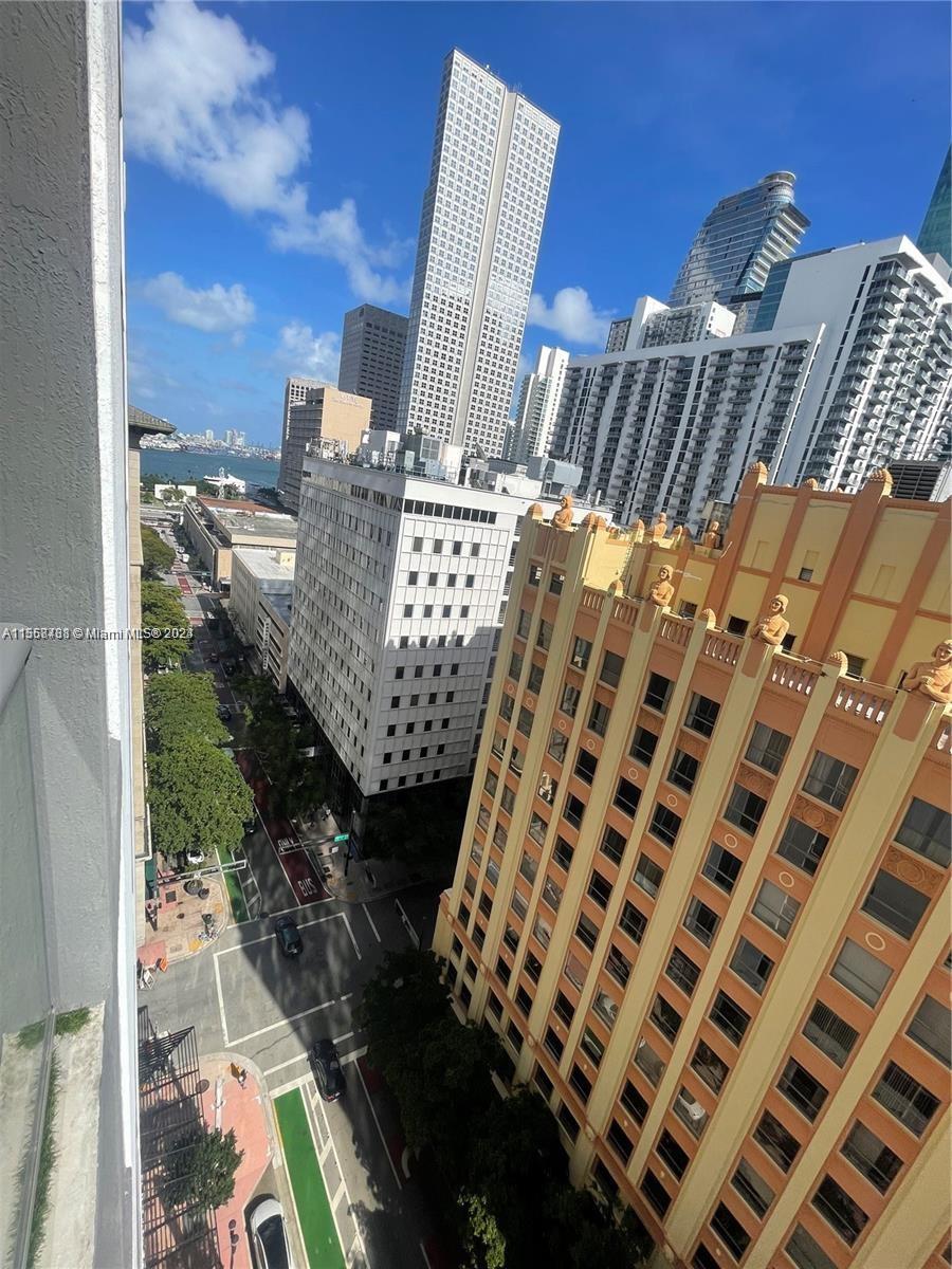 An elevated view shows a city street lined with tall buildings and a nearby waterfront — 151 SE 1st St # 1505, Miami FL 33131, MIAMI, FL