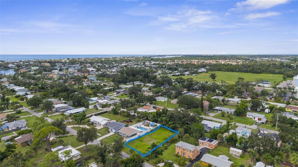 An aerial view shows a vacant, rectangular lot outlined in blue within a residential neighborhood — 216 PAVONIA ROAD, NOKOMIS, FL