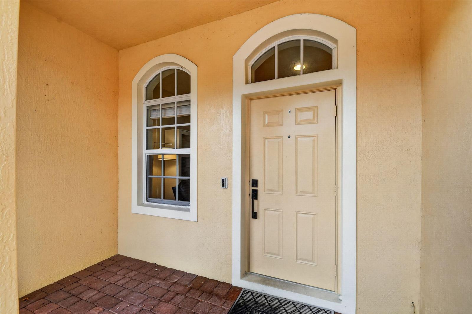 A front entryway features a beige door with a transom window and an arched window — 7392 Briella Drive, Boynton Beach FL 33437, BOYNTON BEACH, FL