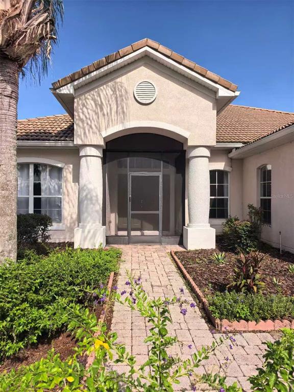 A front exterior view of a house with a brick walkway and screened entryway — 3520 SHOREWOOD DRIVE, KISSIMMEE, FL