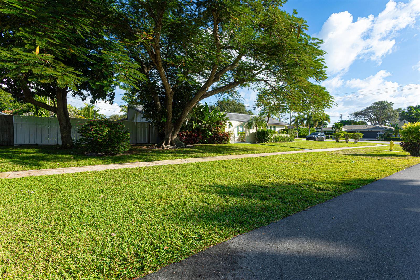 A large tree shades a green lawn in front of a house with a fence — 2013 Ardley Road, North Palm Beach FL 33408, NORTH PALM BEACH, FL