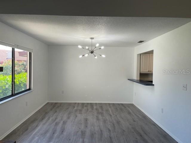A dining area features light gray wood-look flooring, white walls, and a modern sputnik chandelier — 747 SORRENTO INLET, NOKOMIS, FL