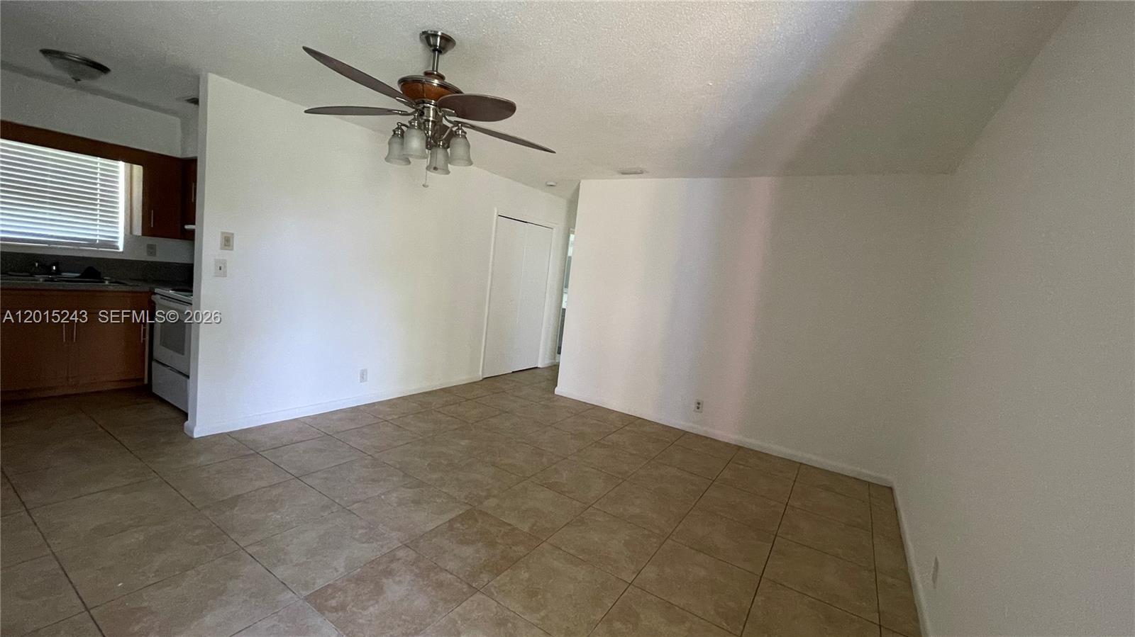 A room with tile flooring, a ceiling fan, and an adjacent kitchen area — 5210 NW 16th St, Lauderhill FL 33313, LAUDERHILL, FL