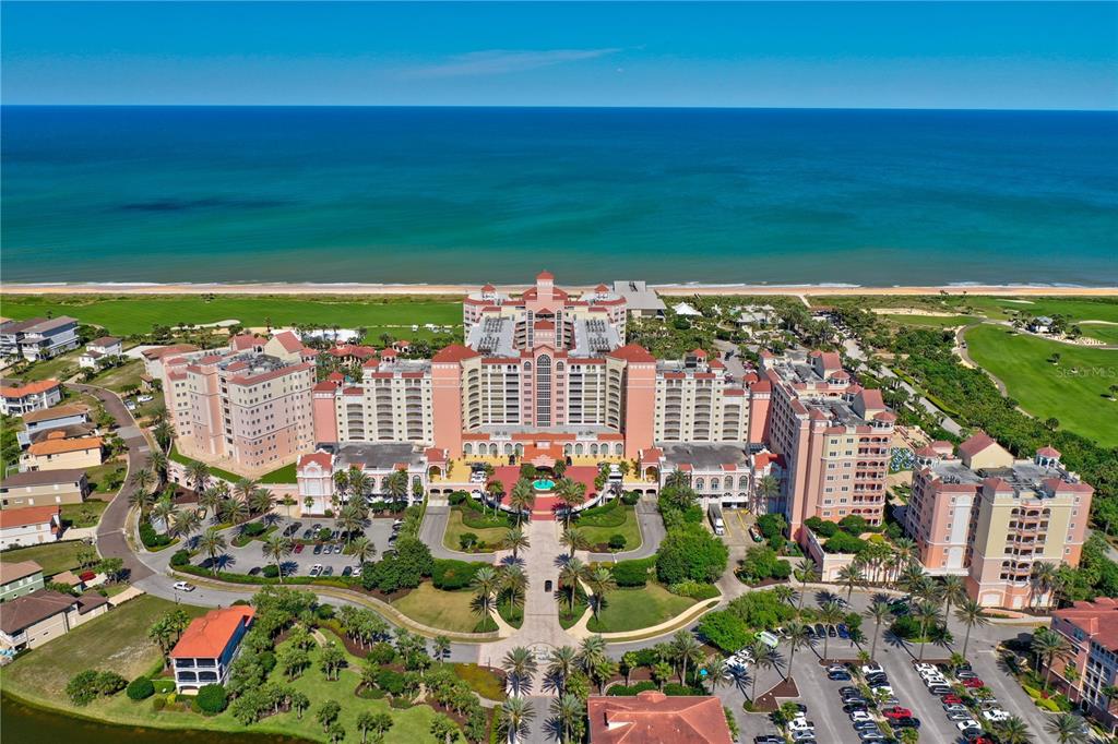 An aerial view shows a large pink resort hotel situated on a beach — 200 OCEAN CREST DRIVE UNIT 622, PALM COAST, FL