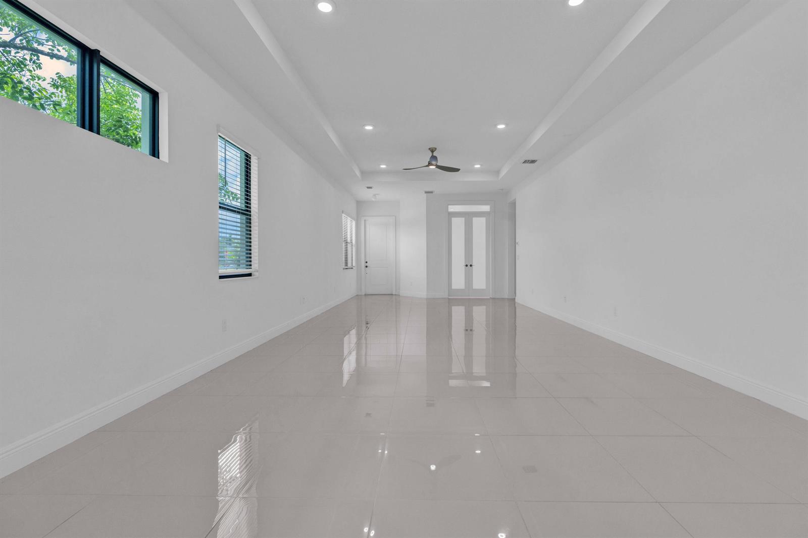 An empty, long room with white walls, recessed lighting, and light-colored tile flooring — 5501 Santa Rosa Lane, Westlake FL 33470, WESTLAKE, FL