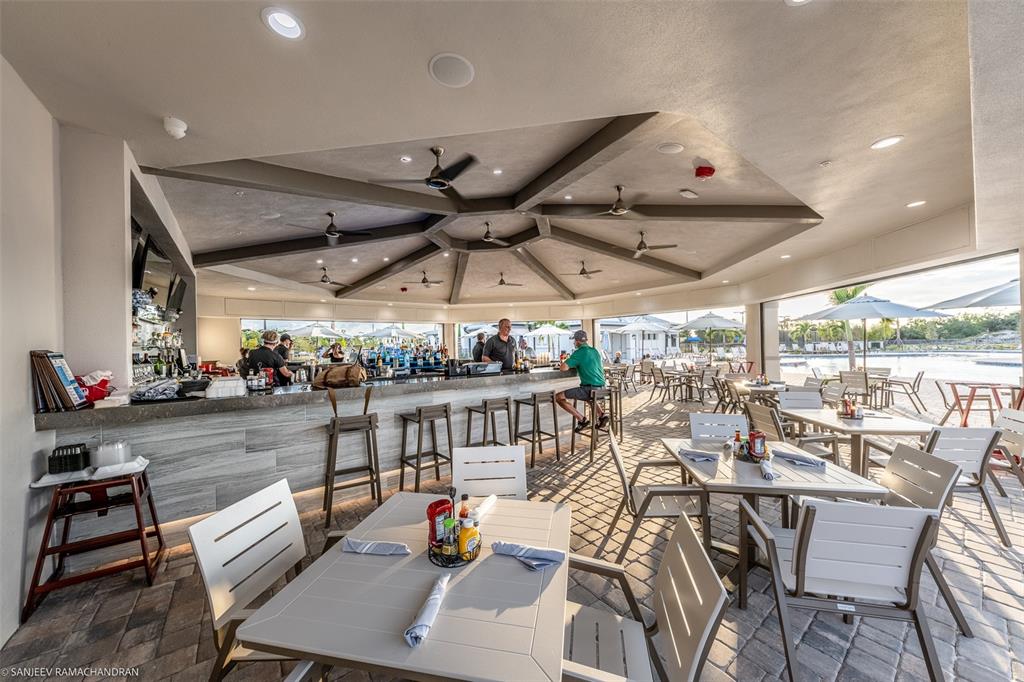 An outdoor bar and dining area features a large covered patio with ceiling fans — 14051 HERITAGE LANDING BOULEVARD UNIT 511, PUNTA GORDA, FL