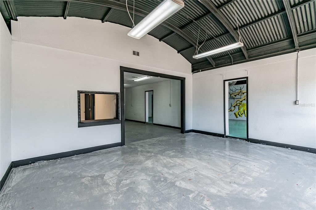 An interior view of a commercial space with a concrete floor and exposed ceiling beams — 3410 E 7TH AVENUE, TAMPA, FL
