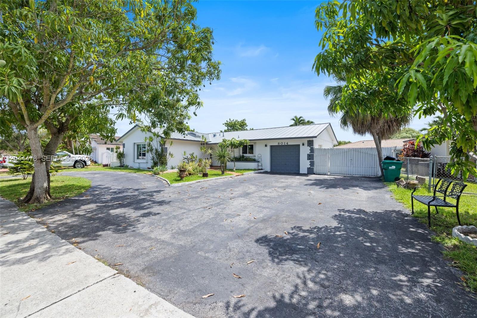 A single-story white house with a metal roof and a large asphalt driveway — 8014 SW 133rd Ct, Miami FL 33183, MIAMI, FL