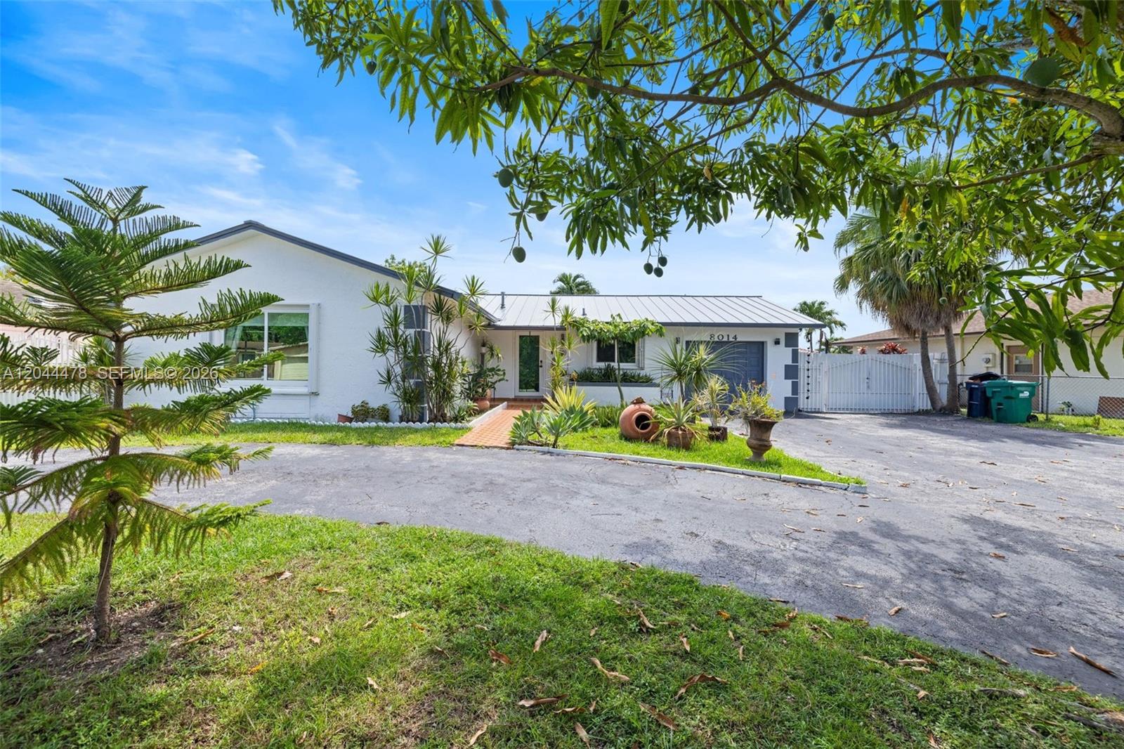A single-story white house with a metal roof, circular driveway, and mature landscaping — 8014 SW 133rd Ct, Miami FL 33183, MIAMI, FL