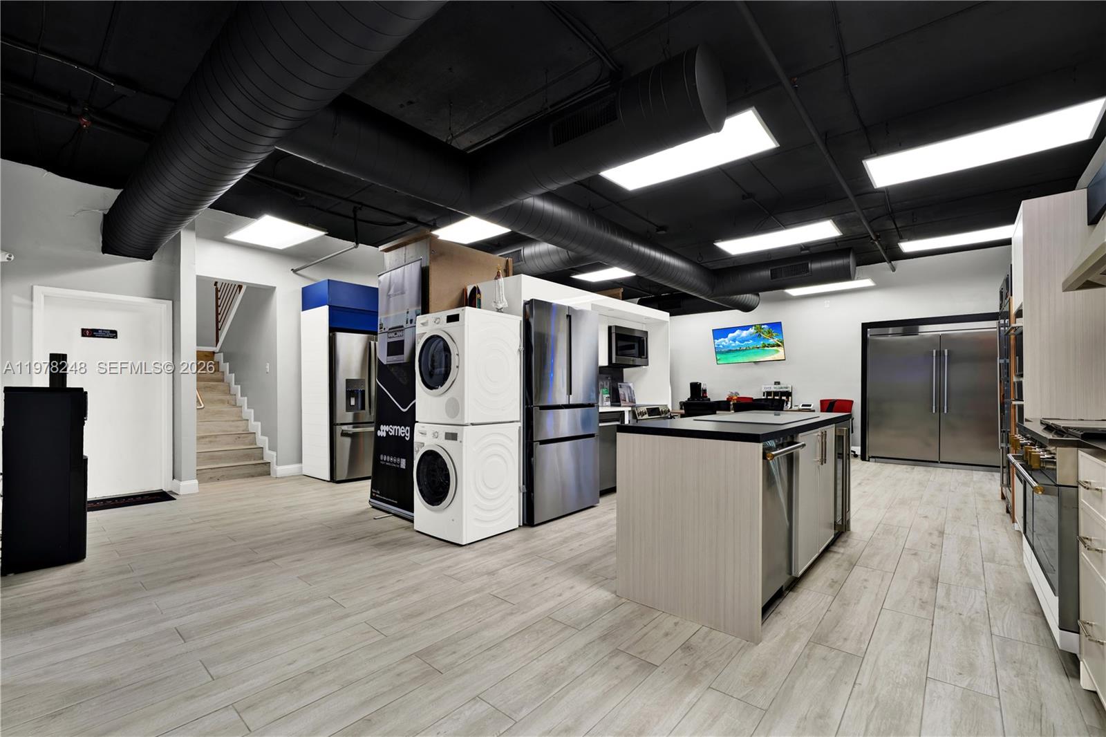 A modern showroom features various kitchen appliances, a stacked washer and dryer, and exposed ductwork — 7770 NW 46th St # 23, Doral FL 33166, DORAL, FL