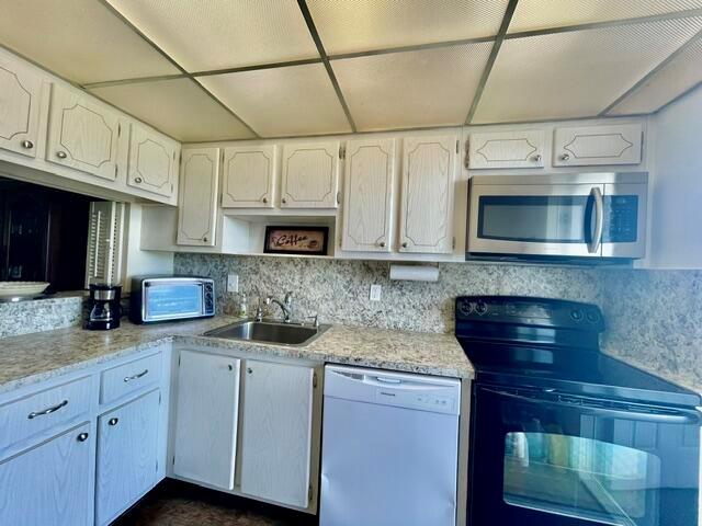 A kitchen features white cabinetry, granite countertops, and black appliances under a drop ceiling — 400 SE 10th Street # 308, Deerfield Beach FL 33441, DEERFIELD BEACH, FL