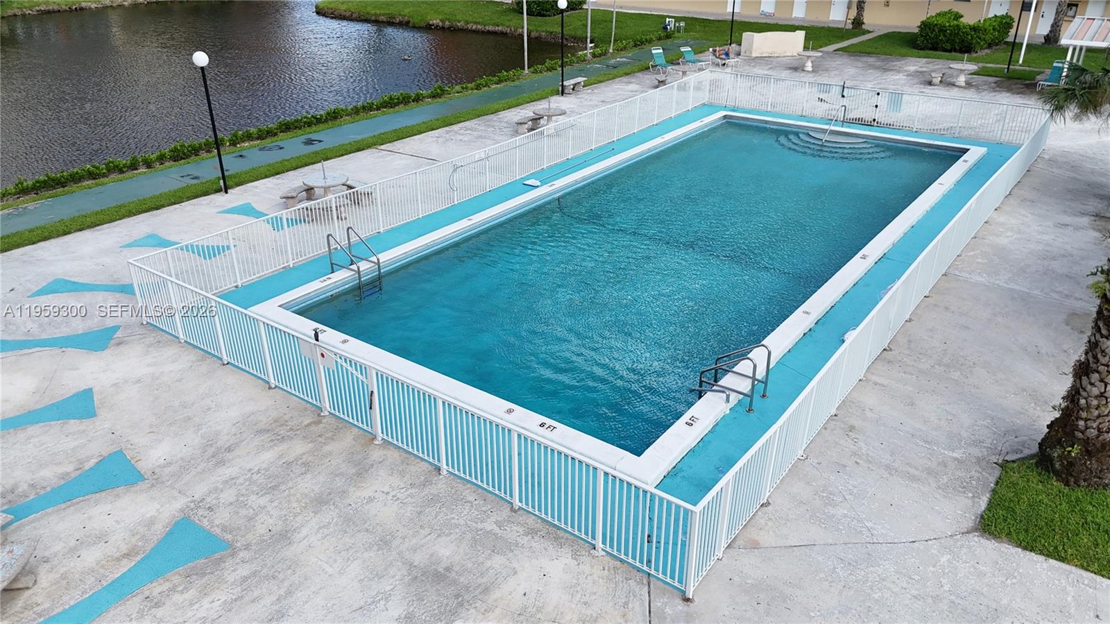 An elevated view shows a rectangular swimming pool enclosed by a white metal fence — 1750 NE 191st St # 1, Miami FL 33179, MIAMI, FL