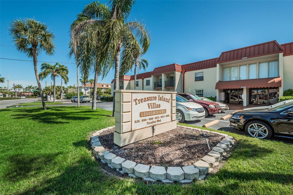 A sign for Treasure Island Villas stands in front of a two-story apartment building — 10365 PARADISE BOULEVARD UNIT 13, TREASURE ISLAND, FL