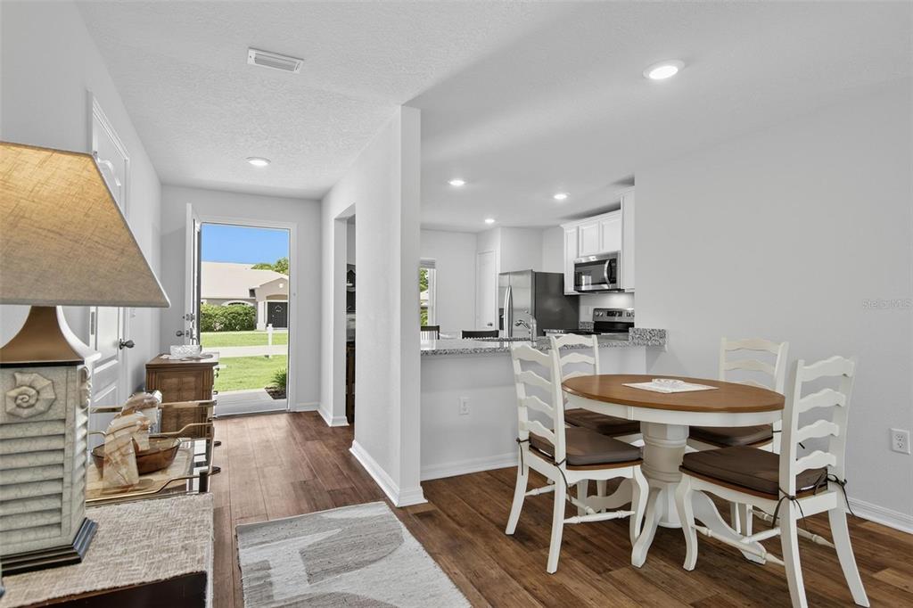 A dining area with a round table and chairs sits adjacent to an open kitchen — 24 PERKINS LANE, PALM COAST, FL